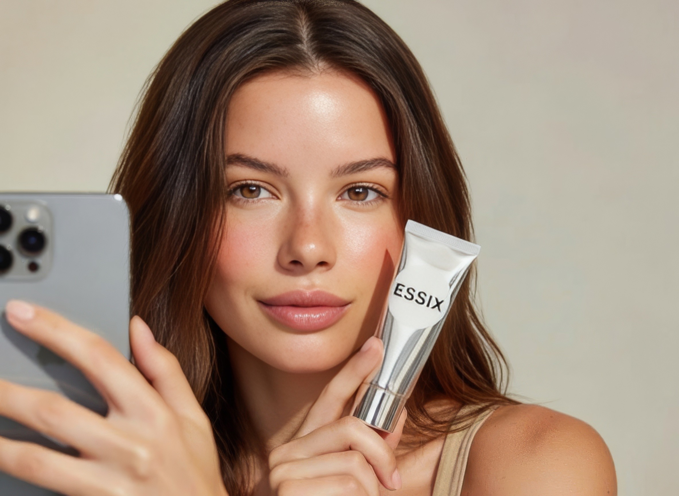 Creator filming a skincare tube with her phone camera