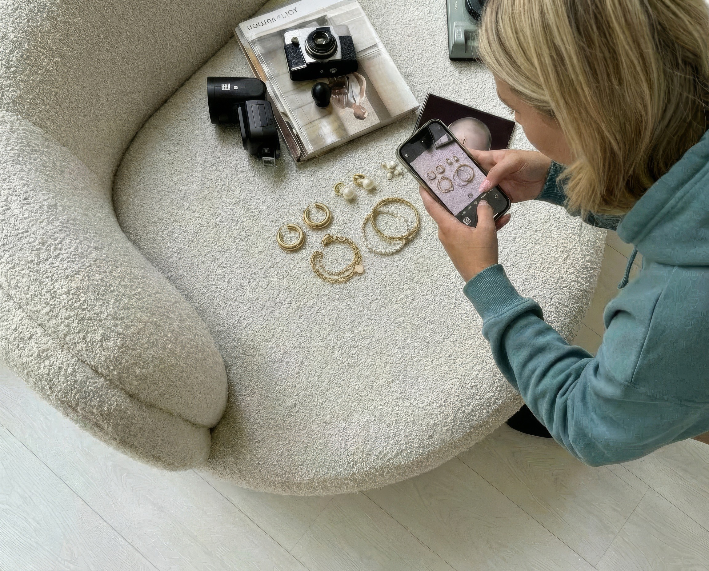 Creator photographing jewellery laid out on a bouclé sofa